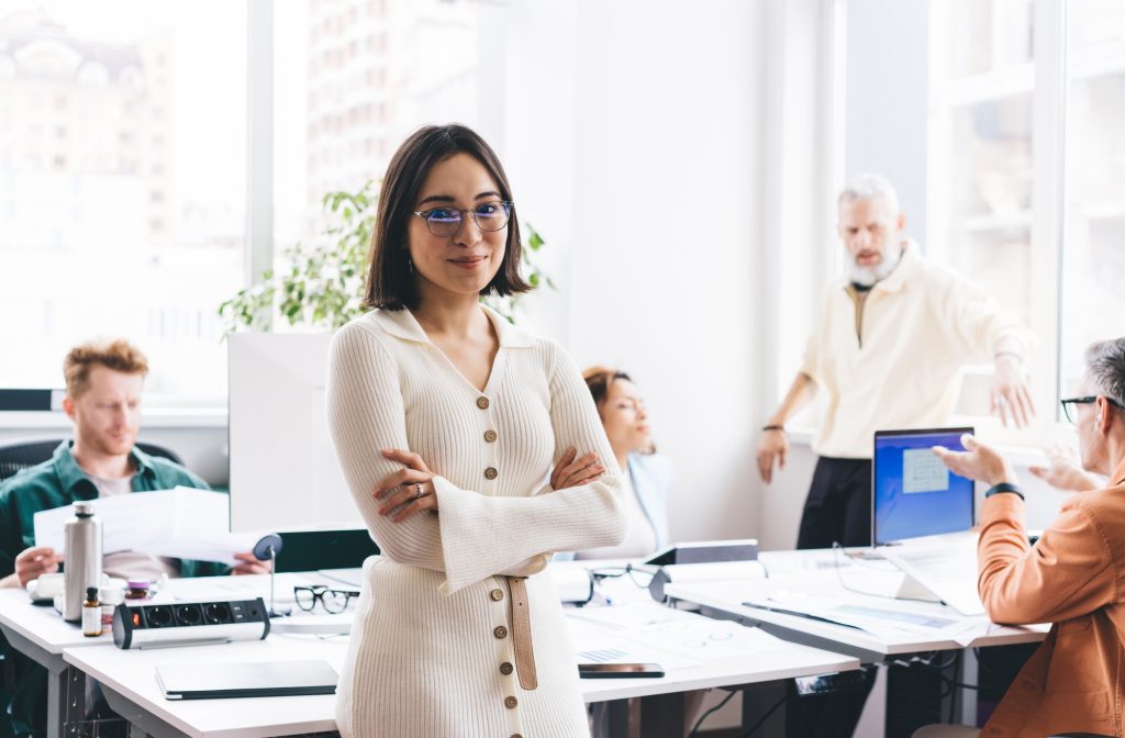 Content Asian woman with arms crossed in workspace